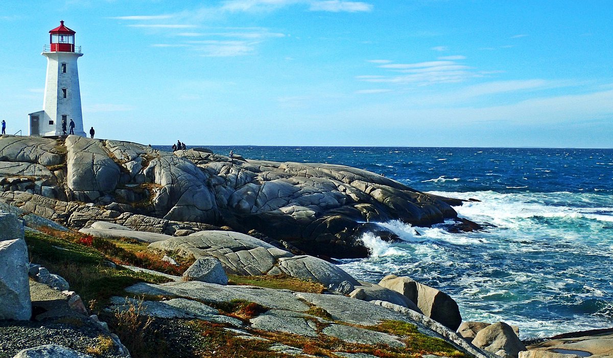 Peggy's Cove Lighthouse on a rocky coastline in Nova Scotia, with waves crashing against the shore